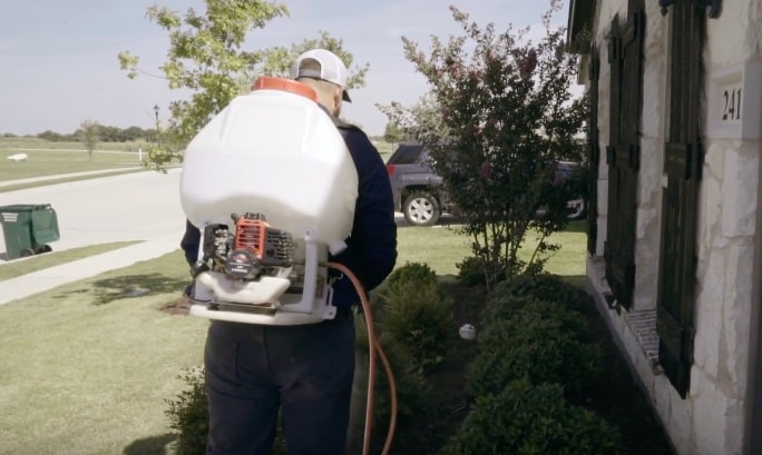 Maple Ridge exterminator performing his services outdoors with some heavy duty tools